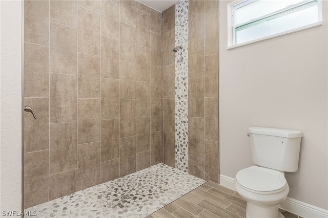 bathroom featuring tiled shower and toilet