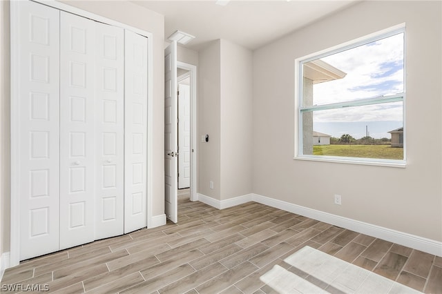 unfurnished bedroom with a closet and light wood-type flooring