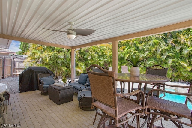 wooden terrace featuring a patio area, a grill, ceiling fan, and a fenced in pool