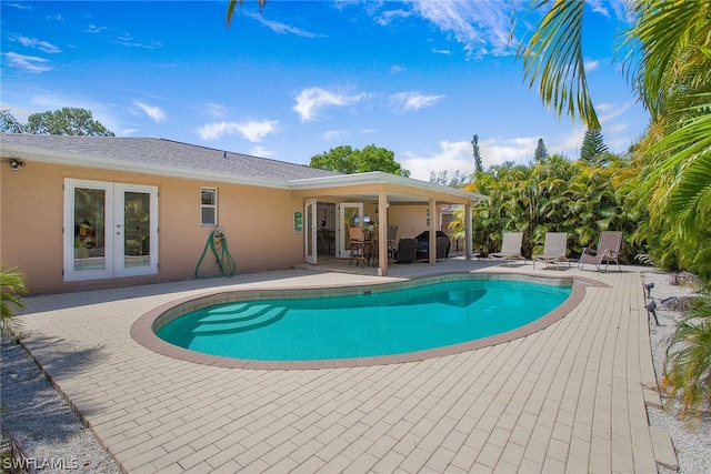 view of swimming pool featuring a patio and french doors