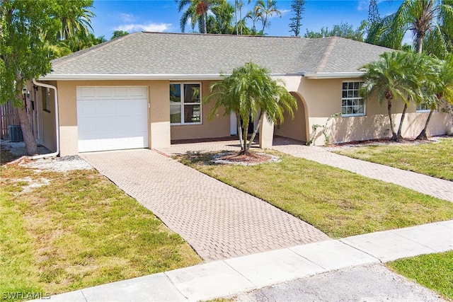 ranch-style home with a garage, central AC, and a front yard