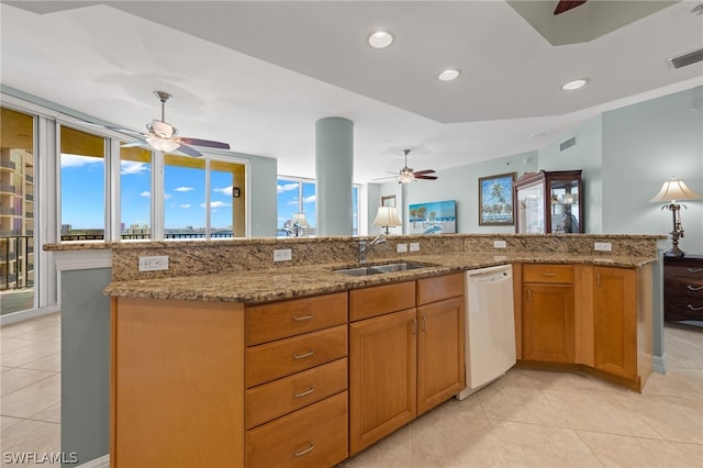 kitchen with an island with sink, sink, light stone counters, and white dishwasher