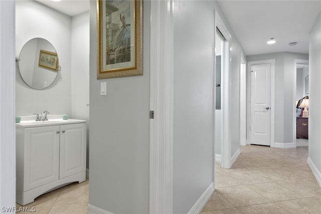 hall featuring light tile patterned flooring and sink