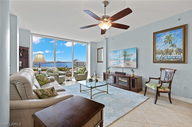 living room with light tile floors, a wall of windows, ceiling fan, and a water view