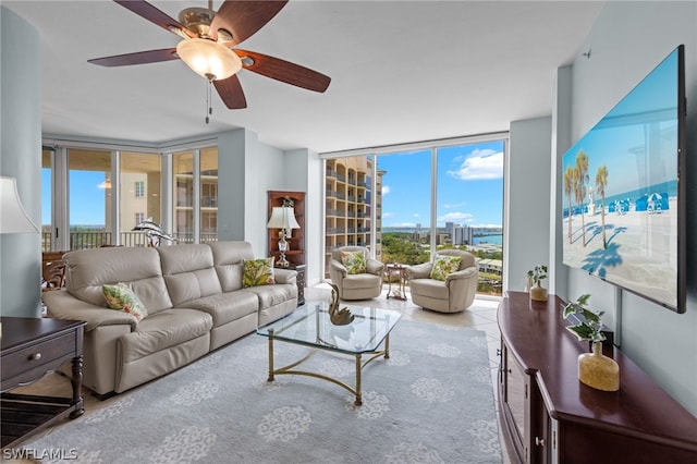 living room with a wall of windows, tile patterned floors, and ceiling fan