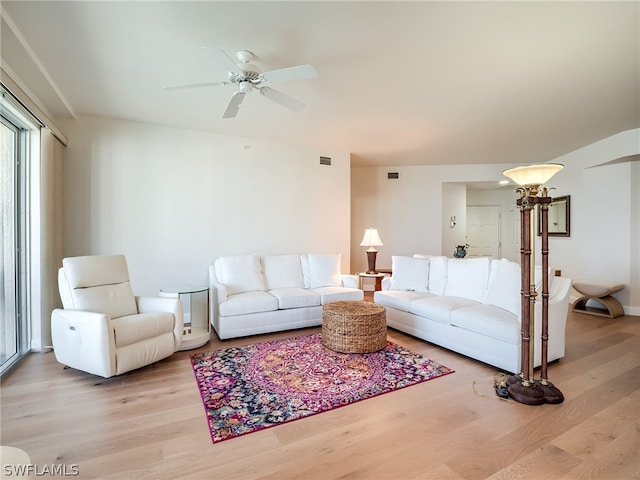 living room with light hardwood / wood-style flooring and ceiling fan