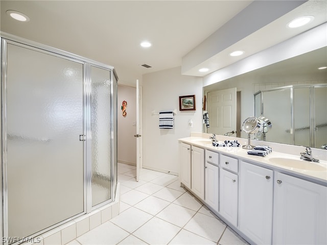 bathroom featuring vanity, a shower with shower door, and tile patterned floors