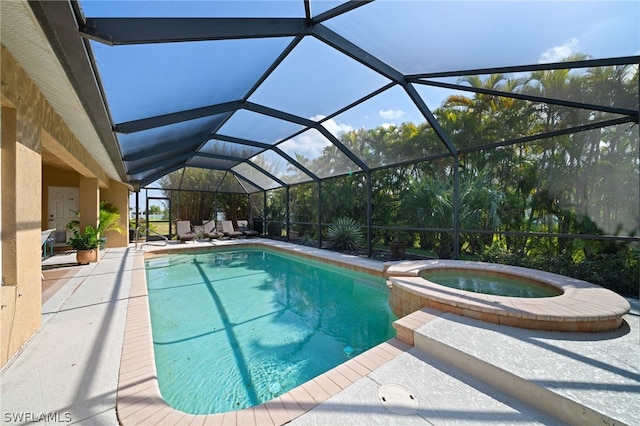 view of pool with an in ground hot tub, a patio, and glass enclosure