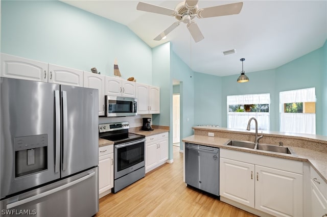 kitchen with pendant lighting, sink, stainless steel appliances, and white cabinets