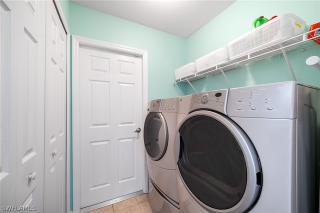 laundry area with light tile patterned floors and washing machine and clothes dryer