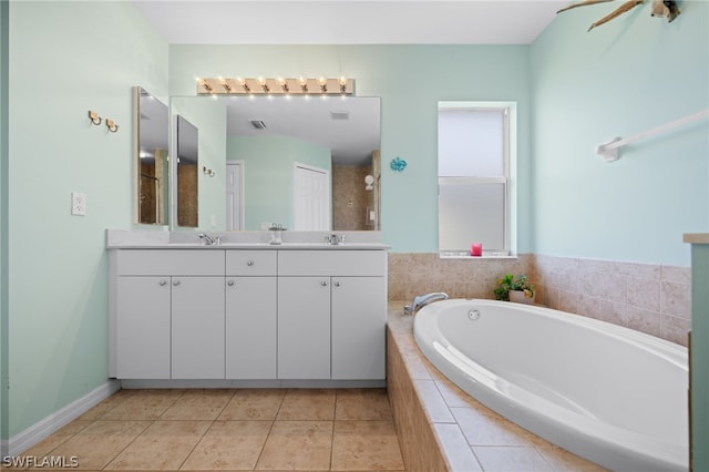 bathroom with vanity, tile patterned flooring, and a relaxing tiled tub