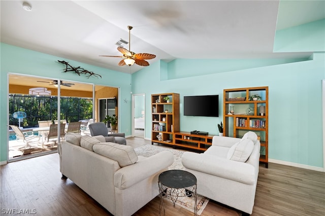 living room featuring vaulted ceiling, dark wood-type flooring, and ceiling fan