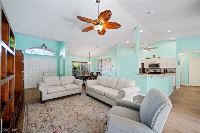 living room with sink, ceiling fan, and light hardwood / wood-style flooring