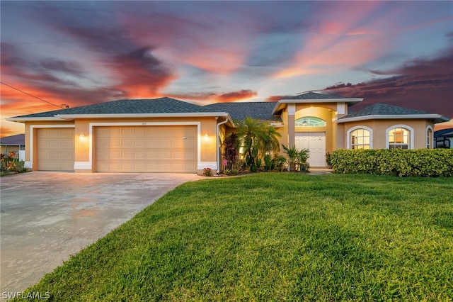 view of front of home with a garage and a yard