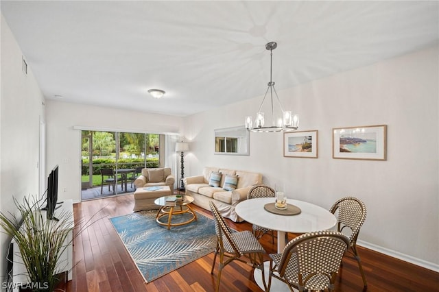 living room with dark wood-type flooring and a notable chandelier