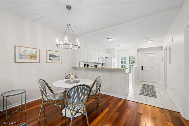 dining area with a notable chandelier and light hardwood / wood-style floors