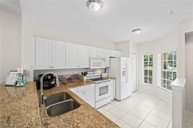 kitchen with white cabinetry, white appliances, stone counters, sink, and light tile floors