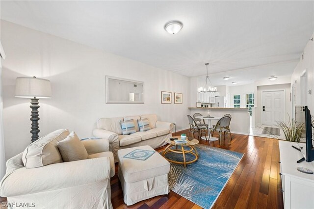 living room with an inviting chandelier and wood-type flooring