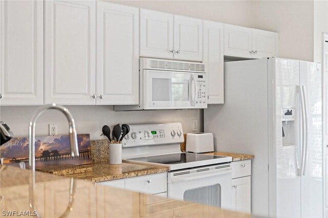 kitchen featuring light stone counters, white cabinets, sink, and white appliances