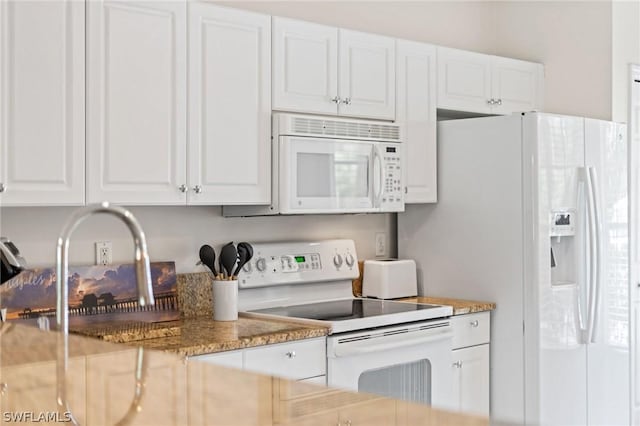 kitchen with light stone counters, white appliances, and white cabinets