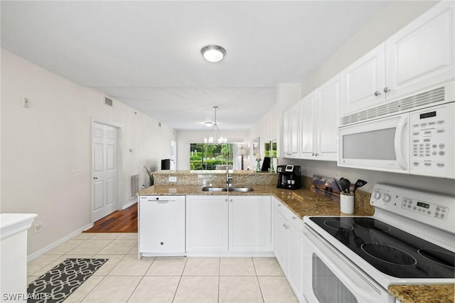 kitchen featuring kitchen peninsula, white appliances, light tile floors, sink, and white cabinetry