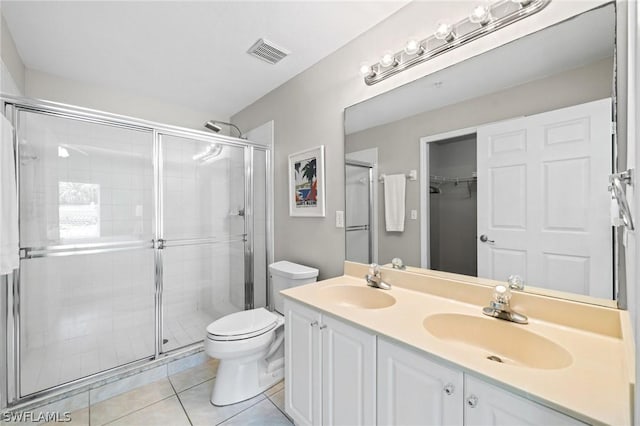 bathroom with vanity, toilet, an enclosed shower, and tile patterned flooring