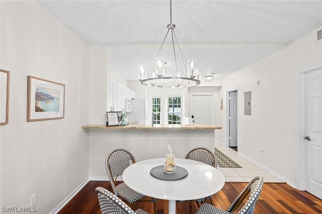 dining area featuring an inviting chandelier and dark wood-type flooring