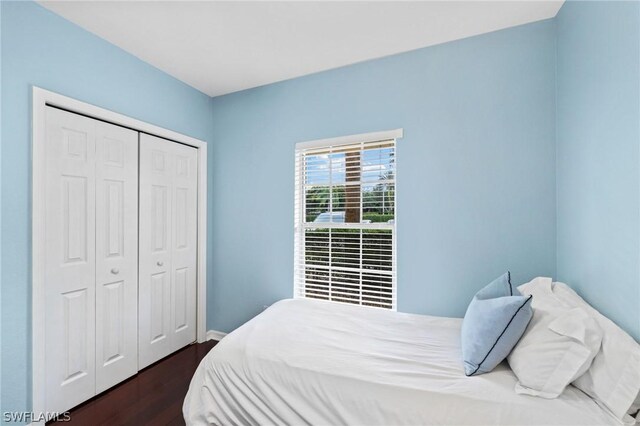 bedroom with dark hardwood / wood-style floors and a closet