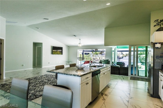 kitchen with sink, a kitchen island, dark stone countertops, stainless steel appliances, and lofted ceiling