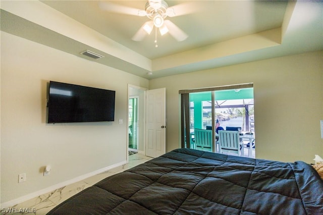 bedroom with ceiling fan, access to exterior, and a raised ceiling