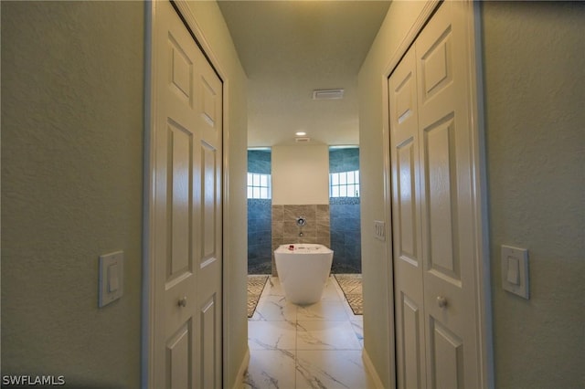 bathroom featuring a tub and tile walls