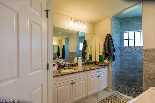 bathroom with vanity and a tile shower