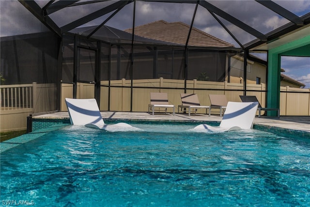 view of swimming pool featuring glass enclosure