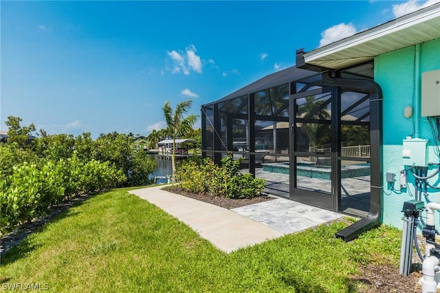 view of yard with a lanai and a water view