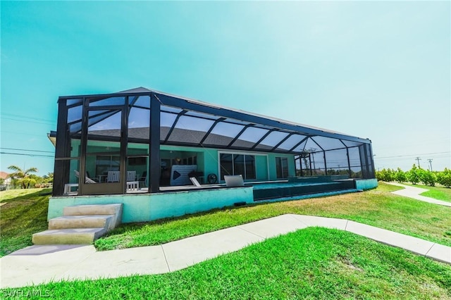 rear view of property featuring a lanai and a yard