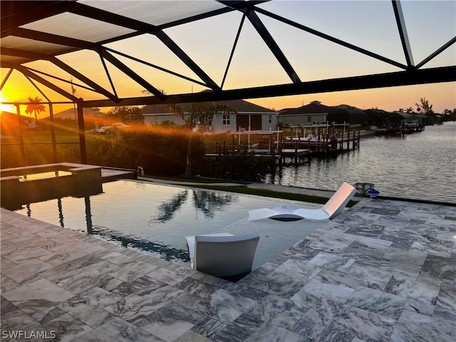 view of dock with glass enclosure, a patio area, and a water view