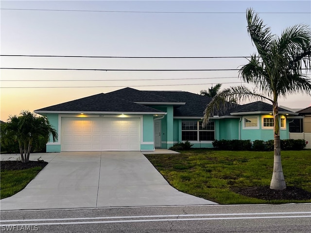 view of front facade with a garage and a yard