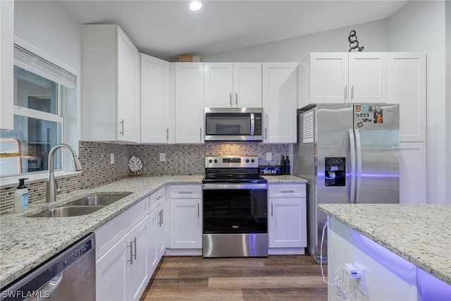 kitchen with stainless steel appliances, lofted ceiling, tasteful backsplash, dark wood-type flooring, and sink