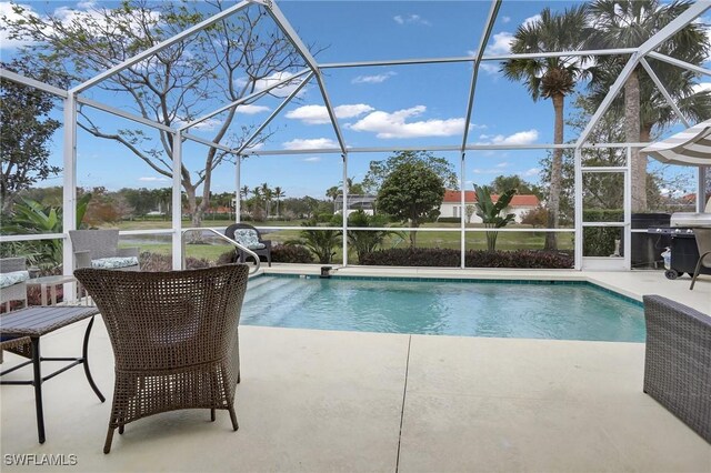 view of swimming pool with grilling area, a lanai, and a patio