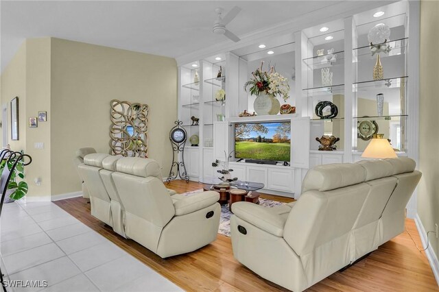 living room featuring ceiling fan, built in features, and light wood-type flooring