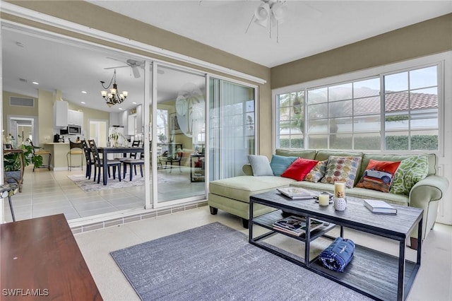 sunroom / solarium featuring ceiling fan with notable chandelier and vaulted ceiling