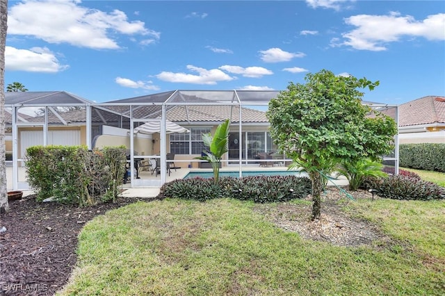 back of property featuring a yard and glass enclosure