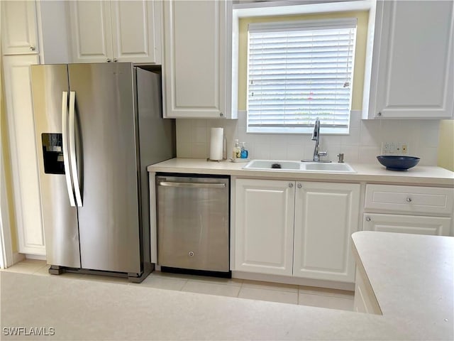 kitchen with stainless steel appliances, sink, and white cabinets