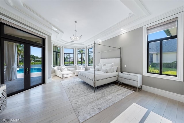 unfurnished bedroom with a tray ceiling, french doors, light wood-type flooring, access to exterior, and a chandelier