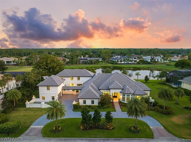 aerial view at dusk featuring a water view