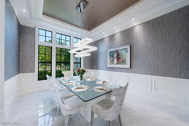 dining area featuring ornamental molding, a tray ceiling, light tile floors, and a chandelier