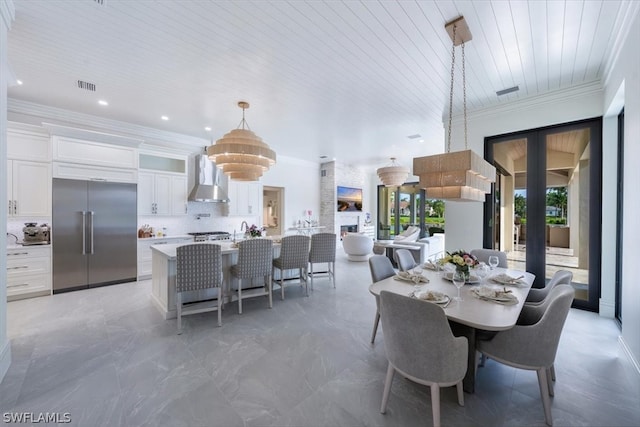 tiled dining space with sink and crown molding