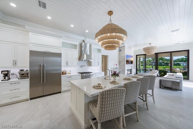 kitchen featuring hanging light fixtures, premium appliances, wooden ceiling, wall chimney exhaust hood, and backsplash