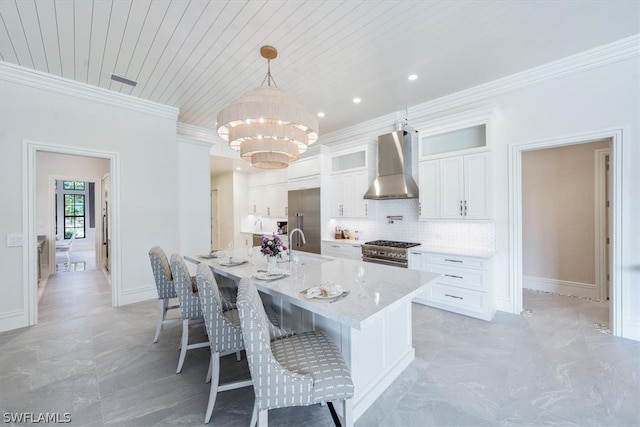 kitchen featuring stainless steel range, decorative light fixtures, light tile flooring, backsplash, and wall chimney range hood