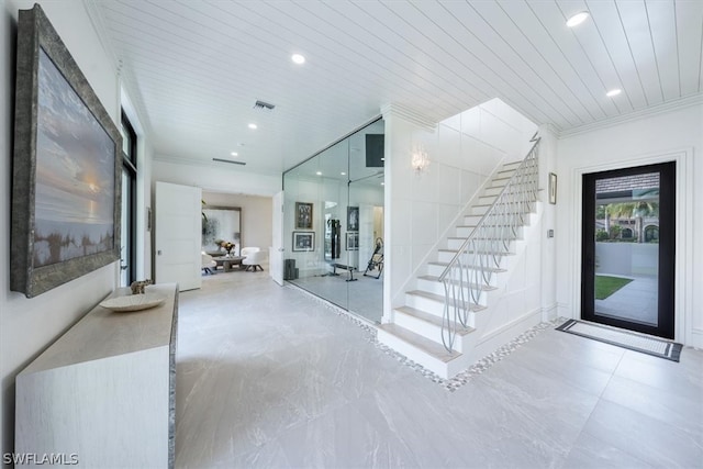 tiled entryway featuring crown molding